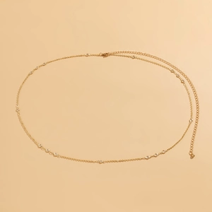 Detail of minimalist gold chain body belt with sparkling zircons and lobster clasp closure