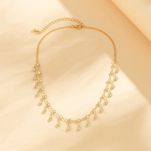 Macro shot of gold tassel body chain with rhinestone pendants and adjustable lobster clasp