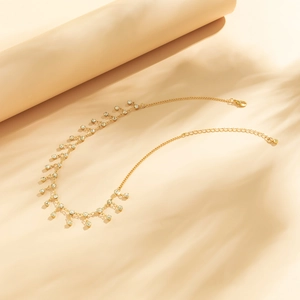 Detailed close-up of golden body chain with sparkling rhinestones and lobster clasp
