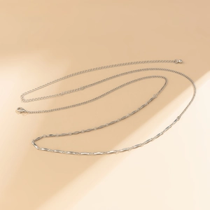 Detail view of multi-layered silver hip chain with lobster clasp and bead charm