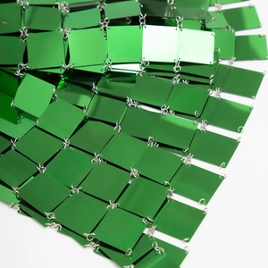 Detail of bright green sequin mesh with metallic square plates and silver ring links