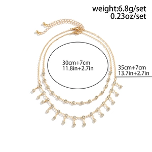Detail view of gold layered body chain with rhinestone tassels and length specifications