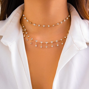 Detailed macro view of double-layer gold choker with sparkling rhinestone tassel accents