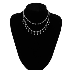 Close-up of a silver body chain with sparkling rhinestone fringe on a black model