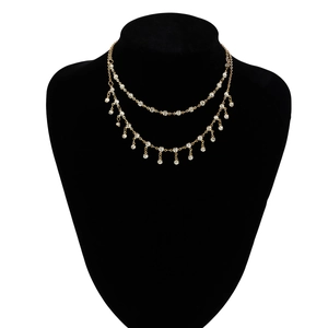 Close-up of gold bohemian body chain with sparkling rhinestone fringe on black mannequin