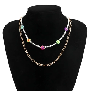 Διπλό κολιέ με χάντρες μαργαρίτες και χρυσή αλυσίδα σε μαύρη βάση προβολής