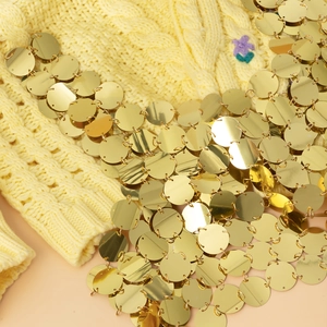 Détail de gilet de bikini en tricot jaune avec paillettes dorées et broderie florale