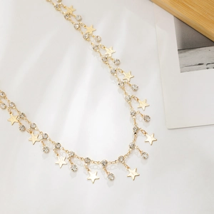 Detail of gold chain with matte star charms and sparkling round rhinestones for women
