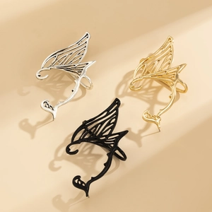 Detailed close-up of dragon wing ear cuffs in vintage silver, gold and matte black finishes