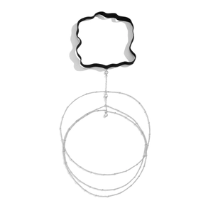 Detail van zilveren dijketting met gelaagde kralen en witte parels op zwarte elastiek