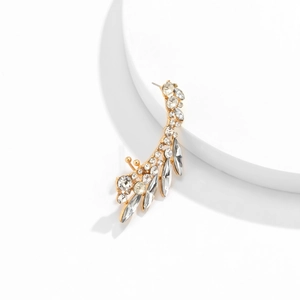 Detailed view of gold elf ear cuff with rhinestones and marquise stones on white base
