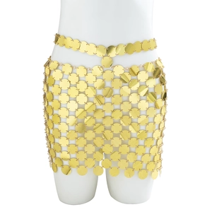 Détail de la jupe de corps à paillettes dorées avec disques métalliques sur mannequin
