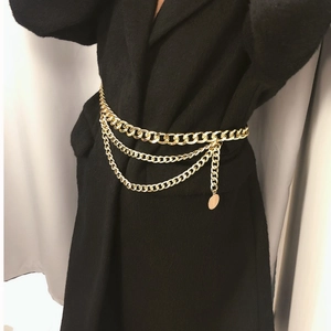 Sexy multilayer gold metal body chain with tassel pendant on black coat background