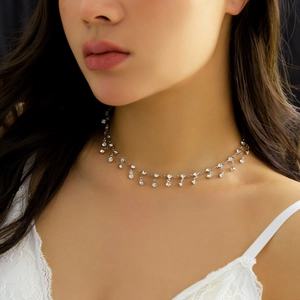 Détail d'une chaîne de corps argentée avec glands en strass sur un mannequin