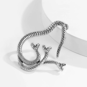 Macro view of vintage silver hydra ear cuff with detailed scale texture on white stand