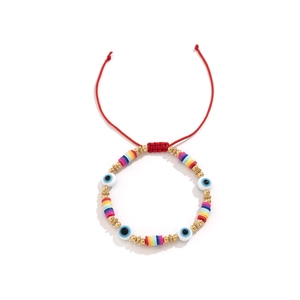 Détail du bracelet tressé rouge avec œil protecteur et perles en argile colorées