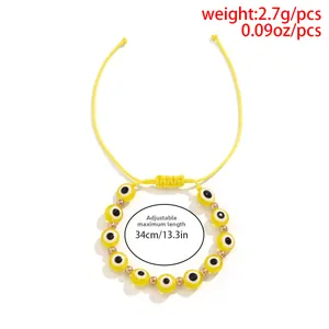 Vue macro d'un bracelet tissé jaune avec œil porte-bonheur et cordon réglable