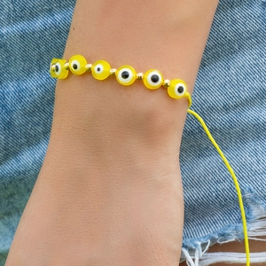 Détail du bracelet en perles Evil Eye jaunes avec inserts dorés et cordon ajustable