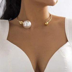 Minimalist gold metal collar necklace with asymmetrical pearl and bead accents on model