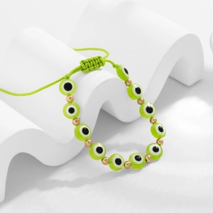 Détail du bracelet bohème œil maléfique vert avec cordon ajustable et perles dorées