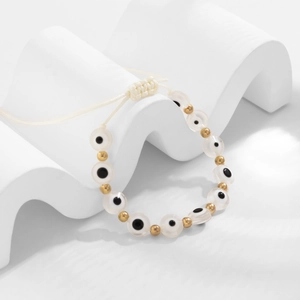 Détail du bracelet en corde tressée avec perles mauvais œil et perles dorées