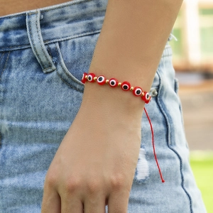 Gros plan d'un bracelet bohème œil protecteur rouge avec cordon ajustable au poignet