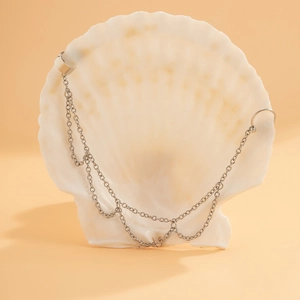 Detail der silbernen Gliederkette mit minimalistischem Ohrhaken auf einer Muschel