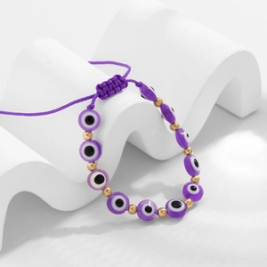 Détail d'un bracelet de perles Mauvais Œil violet avec séparateurs dorés