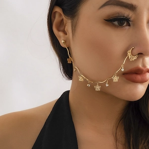 Detailed view of a gold ethnic nose-to-ear chain with butterfly charms and crystals