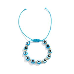 Détail du bracelet œil protecteur bleu tressé ajustable avec perles dorées sur fond blanc