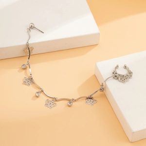 Detail of silver nose-to-ear chain jewelry with butterfly charms and crystal pendants