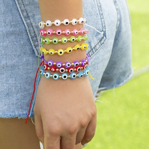 Détail de sept bracelets de perles mauvaises œil colorés portés au poignet avec cordons réglables