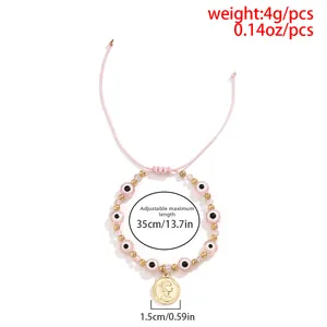 Détail du bracelet perlé avec œil protecteur, pièce Reine Elizabeth II et cordon réglable