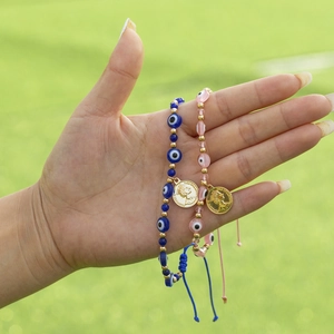 Bracelets de perles mauvais œil ajustables avec médaillons dorés sur fond de pelouse