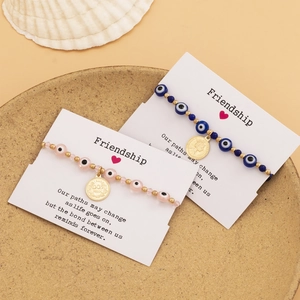 Bracelets d'amitié bohèmes avec œil maléfique et pièces dorées sur carte de présentation