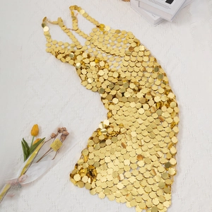 Detail of gold geometric sequin body chain showing metallic discs and link structure