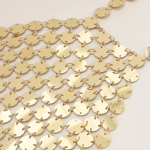 Dettaglio macro della catena per il corpo con paillettes dorate e trama metallica lucida