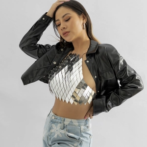 Détail d'une chaîne de corps à paillettes argentées portée avec une veste en cuir noir chic
