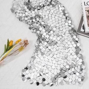 Detailed view of silver sequin top with large circular metallic plates and mirror finish