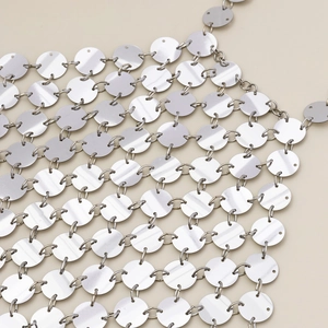 Dettaglio di paillettes metalliche argentate lucide per una catena per il corpo bikini