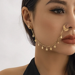 Detailed view of a gold star and moon nose ring with integrated ear stud chain