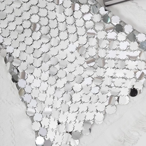 Detailed close-up of metallic silver mirror sequins connected by small metal rings