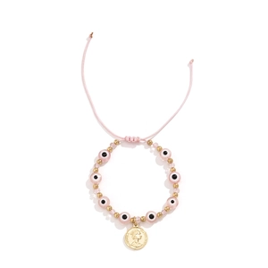Détail de bracelet à perles mauvais œil rose avec pendentif pièce d'or vintage