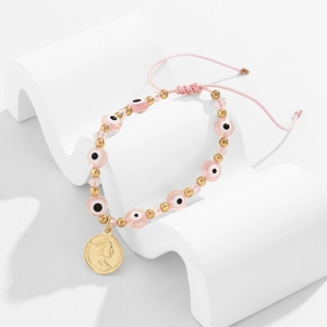Détail des perles mauvaises œil roses et pendentif pièce dorée sur bracelet ajustable