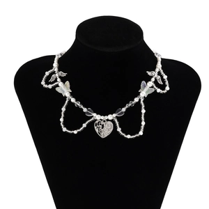 Collar de capas con mariposas y perlas en un soporte de terciopelo negro
