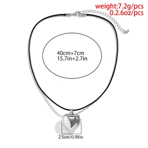 Detail showing oversized silver heart pendant necklace with black velvet cord and measurements