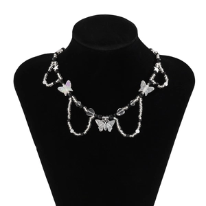 Detalle del collar de mariposa con cuentas de acrílico blancas y negras en soporte