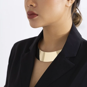 Nahaufnahme des polierten Gold-Chokers auf schwarzem Anzug an einem Model