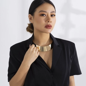 Poliertes goldfarbenes breites Metall-Choker-Halsband am Modell im modernen Punk-Stil