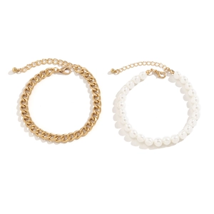 Bracelet de cheville double rang avec chaîne cubaine dorée et perles blanches sur fond blanc